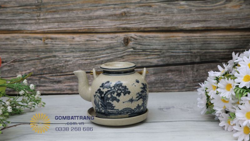 Ấm trà men rạn cổ Bát Tràng dáng tròn vững chắc, họa tiết tùng hữu tình vẽ tay tinh xảo, men rạn loang tự nhiên, quai và nắp bọc đồng sang trọng – biểu tượng của vẻ đẹp bền vững và thanh nhã