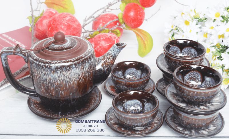 Chiếc ấm trà có dáng tròn đầy, chắc tay, phần thân ấm được phủ lớp men sáng sẫm hòa quyện tạo chiều sâu thị giác