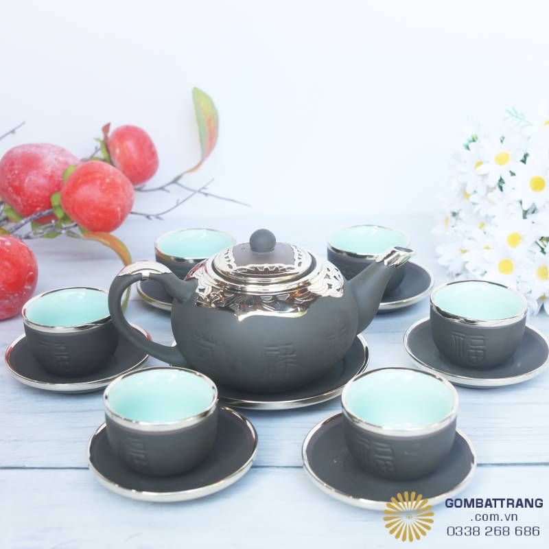 Bộ ấm chén Bát Tràng bọc đồng cao cấp với gam nâu ánh xanh rêu độc đáo, viền vàng sang trọng, mang đến vẻ đẹp vừa cổ điển vừa hiện đại.