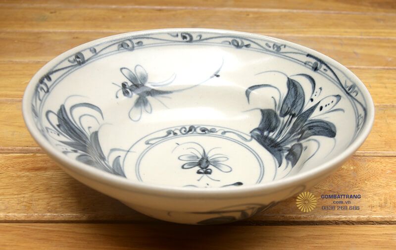 Họa tiết chủ đạo trên toàn bộ sản phẩm là hoa lan và chuồn chuồn được vẽ bằng màu xanh lam đậm trên nền trắng ngà