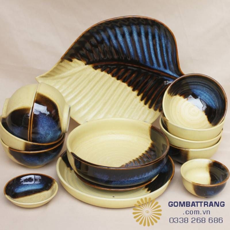  Cận cảnh bộ bát đĩa nhà hàng cao cấp giá rẻ dòng men hỏa biến Bát Tràng với sắc vàng rơm và xanh thiên thạch sang trọng. Thiết kế đa dạng từ đĩa hình lá độc đáo đến bát tô lòng sâu, phù hợp cho mọi không gian bàn tiệc từ truyền thống đến hiện đại.