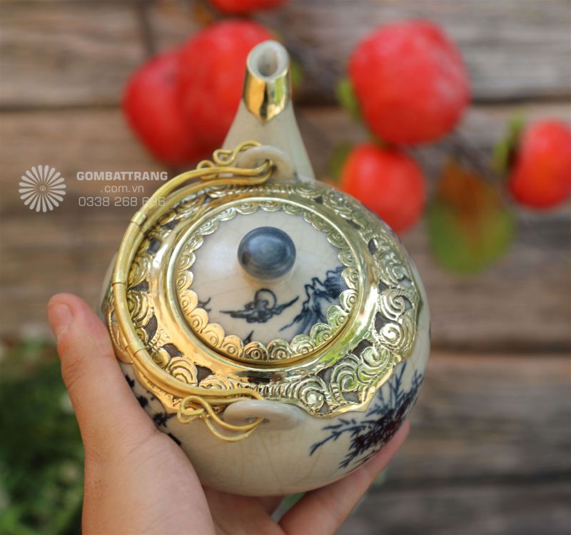 Nắp ấm trà có lớp bọc đồng tạo điểm nhấn trang nhã, góp phần hoàn thiện bộ ấm chén men rạn
