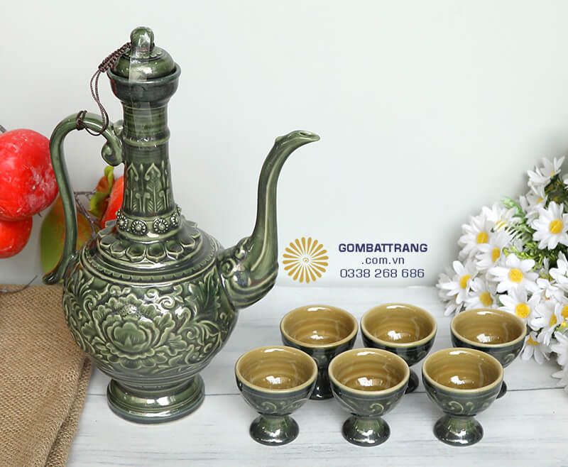 Sự kết hợp hài hòa giữa màu xanh lục của bộ ấm chén và màu nâu vàng bên trong chén tạo nên tổng thể cân đối, sang trọng