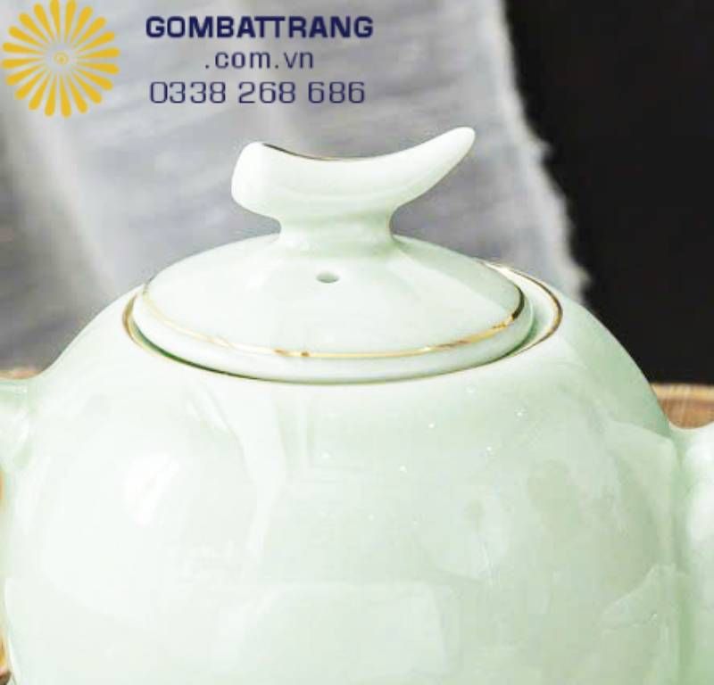 Nắp ấm tròn ôm khít miệng, tỷ lệ vừa vặn đến từng milimét. Mép nắp được viền nâu vàng mảnh, chạy quanh như vòng ánh sáng khép kín.