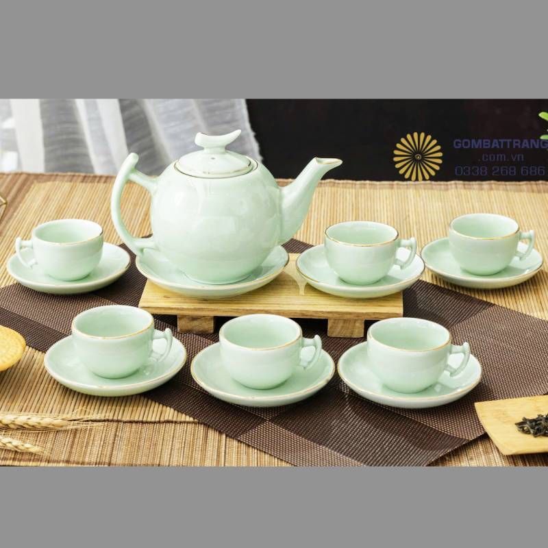 Bộ chén ngọc uống trà bưởi cành ngọc chỉ vàng kim nổi bật với dáng ấm tròn trịa, tách trà mềm mại, men bóng trong như sương sớm. Khi ánh sáng lướt qua, sắc ngọc khẽ chuyển tầng – xanh lam, ánh khói, pha chút vàng mờ – như dòng chảy của thời gian lưu lại trong gốm.