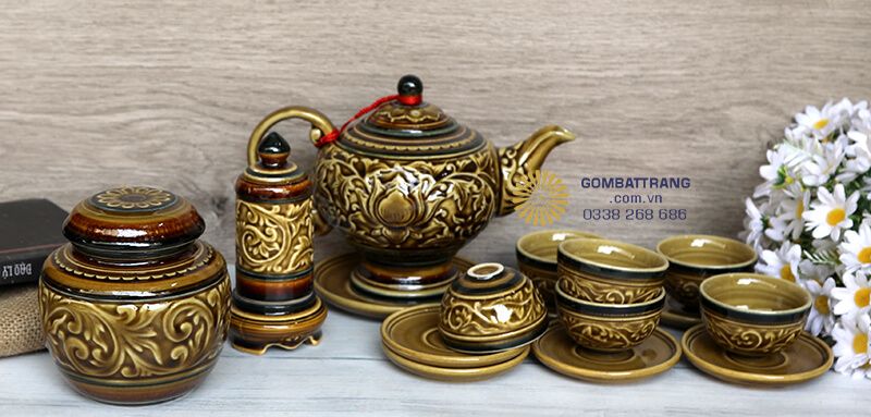 Bộ bình trà Bát Tràng được trang trí bởi họa tiết hoa sen đắp nổi tinh xảo, nổi bật trên nền màu nâu