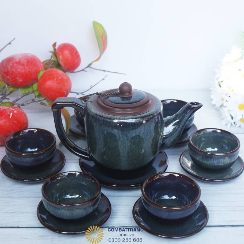 Bộ ấm chén khoác lên mình lớp men xanh rêu ánh đen, dưới ánh sáng phản chiếu lấp lánh như mặt hồ buổi sớm. “Men lửa biến ảo, một thoáng trời đất in trong dáng ấm.”