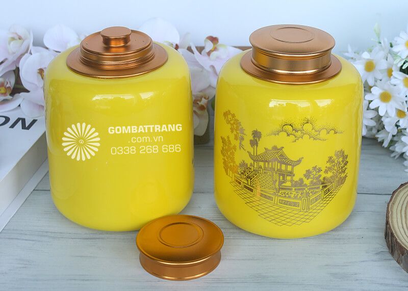 Bộ đôi hộp đựng trà bằng sứ được chế tác tinh xảo từ chất liệu sứ cao cấp, phủ men vàng nổi bật, tạo cảm giác sang trọng và quyền quý