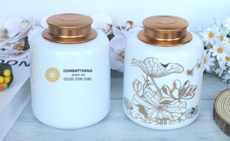 Lọ đựng chè đẹp hoa sen khoe sắc cùng lá sen uốn lượn uyển chuyển, được vẽ tay tinh xảo bằng màu vàng đồng nổi bật trên nền sứ trắng