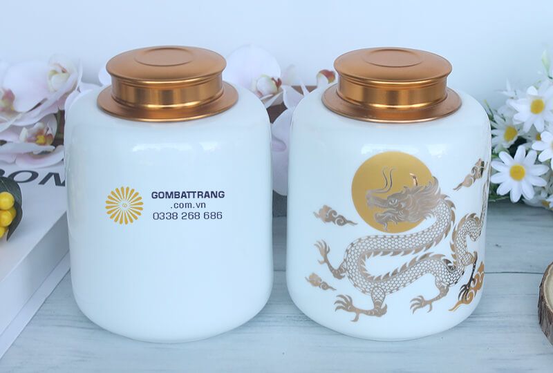 Trên thân lọ đựng trà gốm sứ, hình ảnh con rồng được vẽ vàng, bay lượn uy nghiêm giữa mây trời