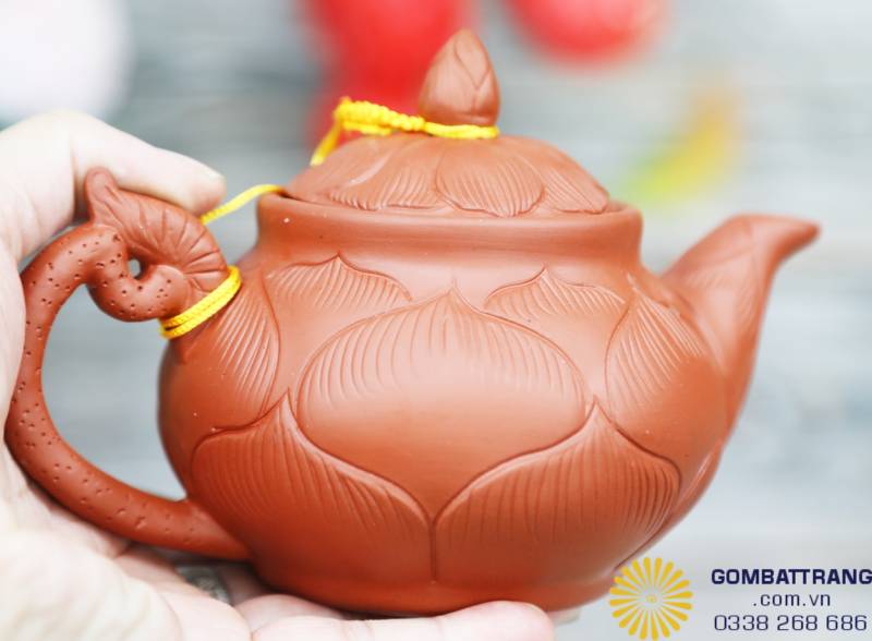Chiếc ấm sen Bát Tràng với thân khắc nổi thủ công, từng đường cánh sen mềm mại, tự nhiên. Thiết kế vừa tay, vòi cong 30° cho dòng chảy đều, mang nét đẹp mộc mạc mà sang trọng.