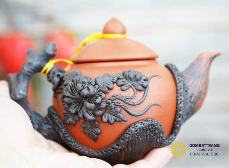 Thân ấm khắc hoa cúc thủ công, mềm mại và sống động, đậm hồn nghệ nhân làng gốm.