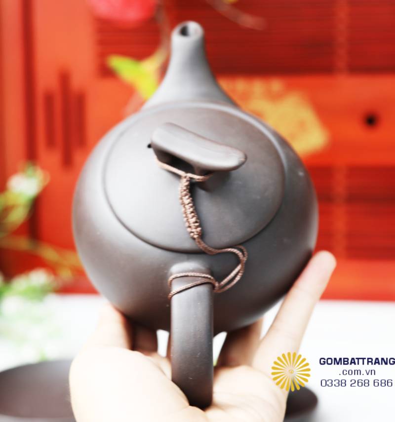 Cận cảnh phần nắp và quai ấm, thể hiện độ hoàn thiện của chi tiết dây da thủ công nối nắp và quai. Bề mặt mịn, đều màu, phần cổ ấm được bo nhẹ tạo cảm giác mềm mắt, dễ cầm.