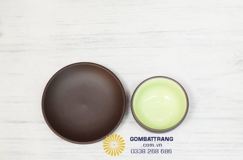 Chén nhỏ nhưng lòng men xanh phản sáng tinh khiết. Tôi chọn sắc men này để tạo điểm nghỉ cho mắt giữa nền nâu sậm của đất, như giọt sáng an lành giữa không gian trầm mặc của trà đạo.