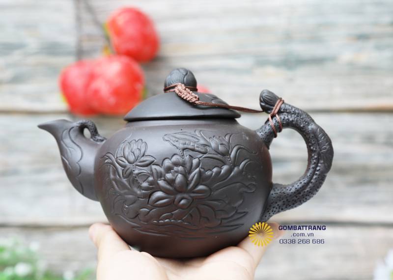 Cận cảnh thân ấm khắc hoa sen nổi mềm mại, cho thấy sự tỉ mỉ và tinh xảo của nghệ nhân.