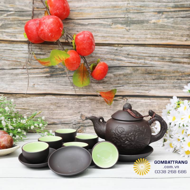 Toàn bộ bộ trà được đặt trong không gian decor sang trọng, làm nổi bật màu nâu trầm tinh tế và hoa văn sen nổi.