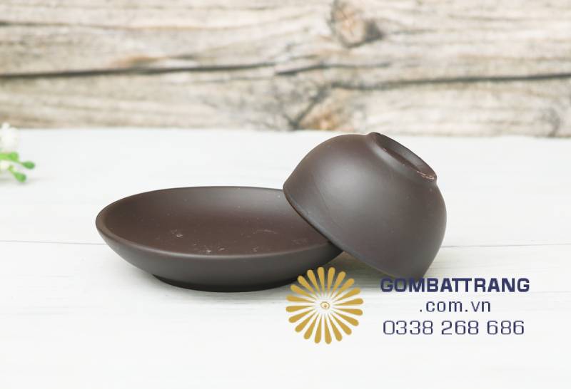 Đĩa và nắp ấm đặt song song phô bày độ mịn và viền men sắc gọn, thể hiện tinh thần tối giản và sự tôn trọng tuyệt đối với nghề gốm thủ công.