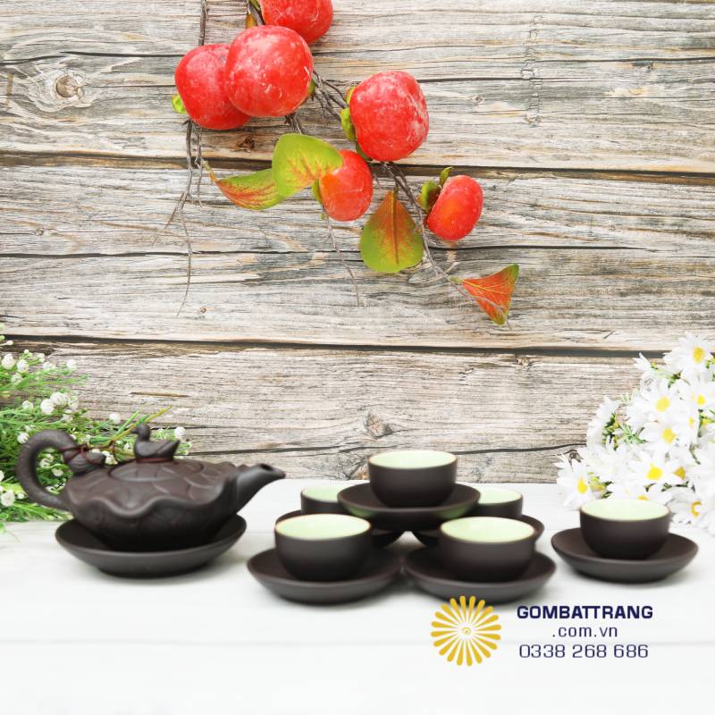 Bộ bình trà Bát Tràng lá sen được sắp đặt cân đối, chén xếp vòng tròn quanh ấm tạo bố cục tròn đầy, tượng trưng cho sự hài hòa và viên mãn.