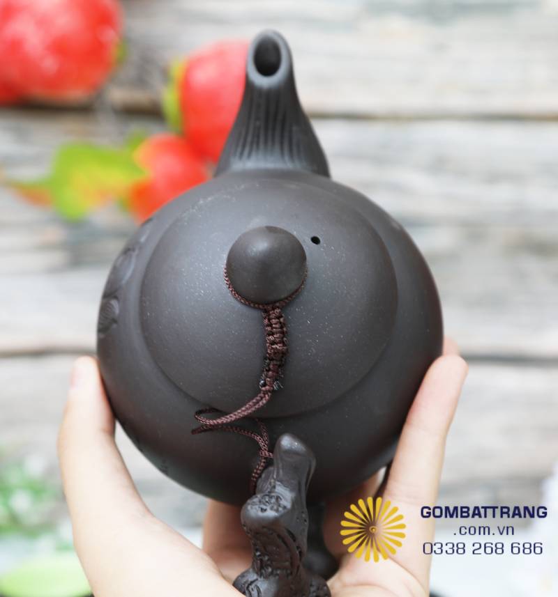 Góc nhìn từ trên xuống cho thấy nắp ấm chóp nhọn, nối quai bằng dây bện thủ công. Thiết kế vững chắc, giữ nhiệt tốt và vẫn giữ được nét thanh thoát đặc trưng của gốm Việt.