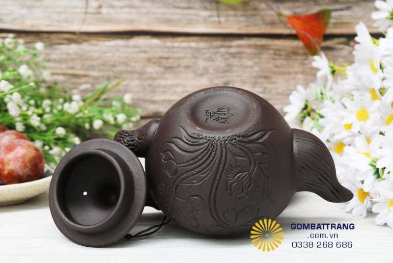 Thân ấm khắc hoa sen khéo léo, từng đường nét như kể lại câu chuyện về sự tĩnh lặng và lòng kiên trì của người nghệ nhân. Mỗi chi tiết đều mang linh hồn của đất Bát Tràng.