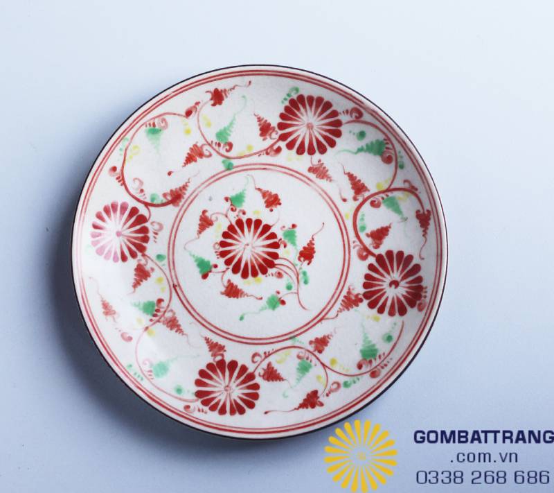 Đĩa tròn như một bức tranh tròn trịa với trung tâm là đóa hoa đang nở, bao quanh bởi các đường dây leo uyển chuyển.