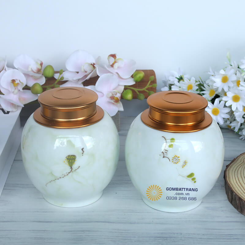 Họa tiết hoa cỏ thanh nhã được vẽ tay nhẹ nhàng trên nền gốm trắng, tượng trưng cho sự thanh khiết, thuần khiết của người yêu trà