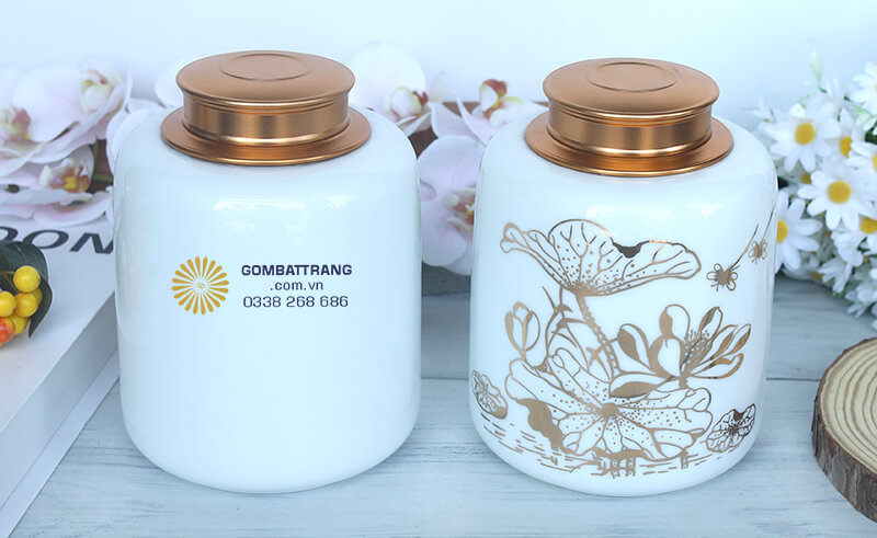 Lọ đựng chè đẹp hoa sen khoe sắc cùng lá sen uốn lượn uyển chuyển, được vẽ tay tinh xảo bằng màu vàng đồng nổi bật trên nền sứ trắng