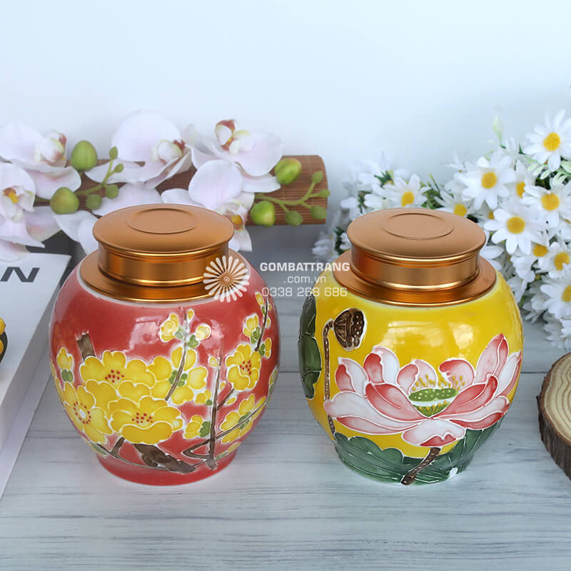 Hũ màu đỏ cam nổi bật với họa tiết hoa mai vàng – biểu tượng của mùa xuân, may mắn và thịnh vượng