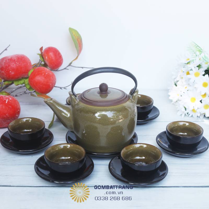 Bộ ấm chén gốm Bát Tràng men nâu hiện lên với vẻ đẹp giản dị mà tinh tế, mang trong mình hơi thở của làng gốm truyền thống nhưng vẫn toát lên sự sang trọng hiện đại. Điểm nhấn đầu tiên chính là chiếc ấm dáng cao, thân tròn đầy đặn, gợi cảm giác vững chãi và hài hòa
