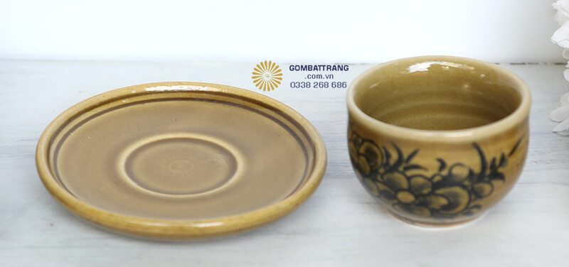 Đĩa lót được chế tác cùng chất liệu gốm sứ Bát Tràng, màu nâu vàng hài hòa với tổng thể bộ ấm trà