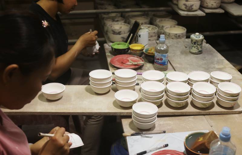 Nghệ nhân Bát Tràng tỉ mỉ hoàn thiện từng chiếc bát đĩa hoa sen trang trí, bảo đảm chất lượng trước khi đưa ra thị trường.