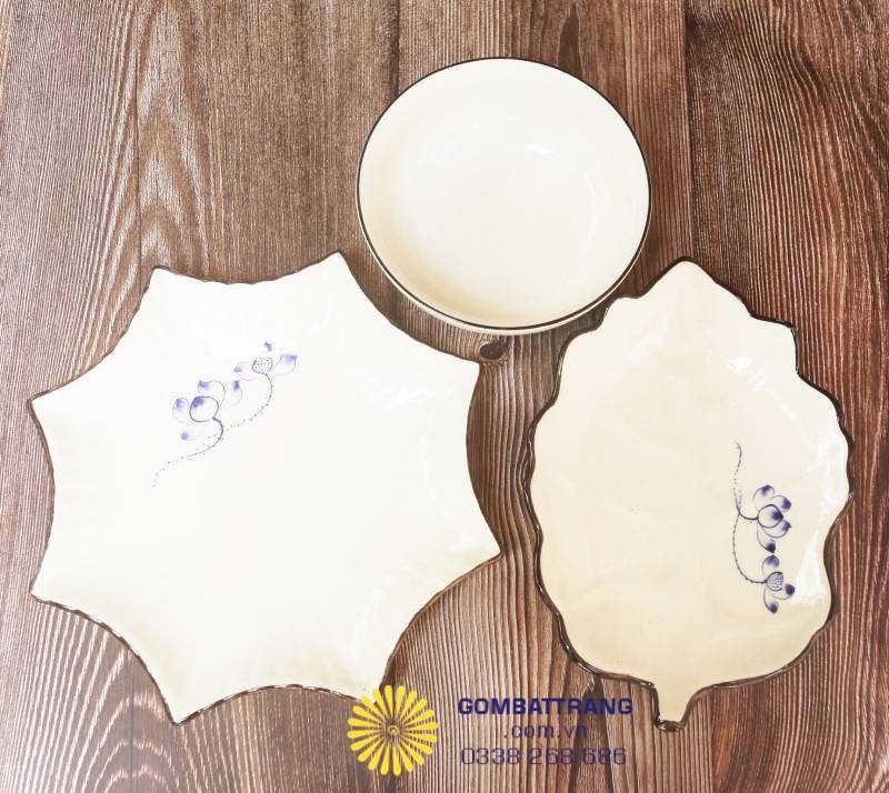 Đĩa gốm Bát Tràng hình lá và hình hoa độc đáo, họa tiết sen xanh nhẹ nhàng, thích hợp bày món ăn trang trí, làm nổi bật không gian bàn tiệc.