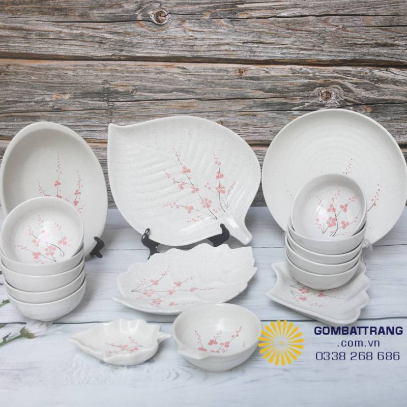 Bộ bát đĩa đầy đủ gồm đĩa tròn, đĩa lá và chén cơm; họa tiết hoa đào nổi bật chính giữa, thích hợp cho bữa cơm sum họp gia đình.