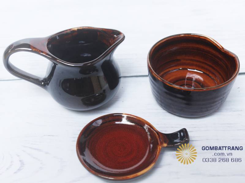 Bộ phụ kiện gốm Bát Tràng men nâu, gồm ly, bát nhỏ và đĩa kê, kiểu dáng gọn gàng, tinh xảo trong từng chi tiết.