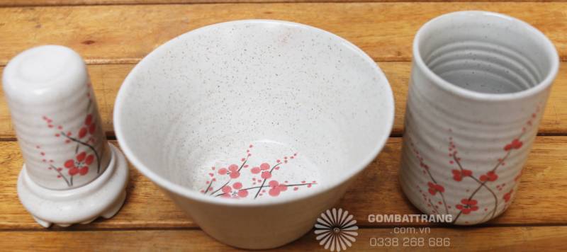 Cốc uống nước, bát ăn và lọ gia vị đồng bộ hoa văn hoa đào, thể hiện sự tinh tế trong từng chi tiết nhỏ nhất của bộ sản phẩm.