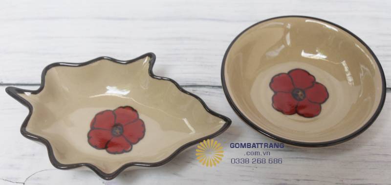Hai chiếc đĩa chấm sứ nhỏ Bát Tràng hoa đỏ như một cặp đôi đồng điệu: dáng tròn gọn gàng, men kem ngà mộc mạc, hoa đỏ rực rỡ nổi bật.